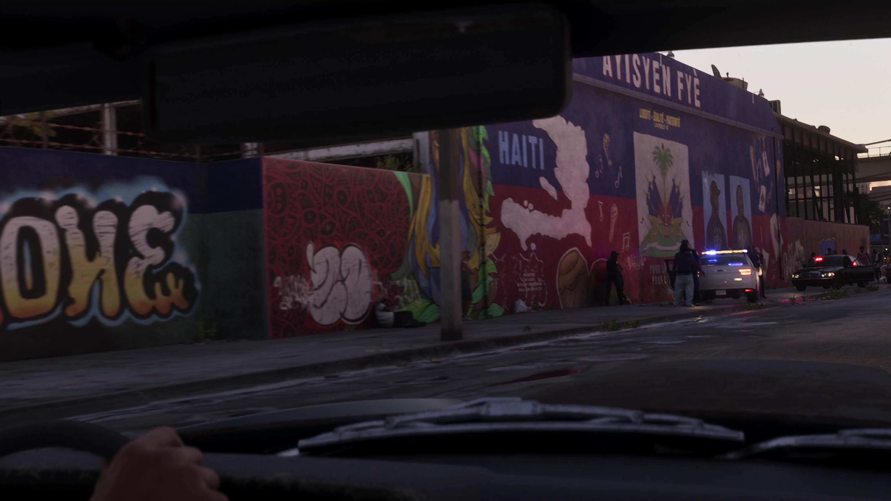 The La Perle warehouse in Trailer 2 — Haitian pride still loud and clear, but that S4SLIFE tag? Ghosted. Rockstar's selective memory at its finest.